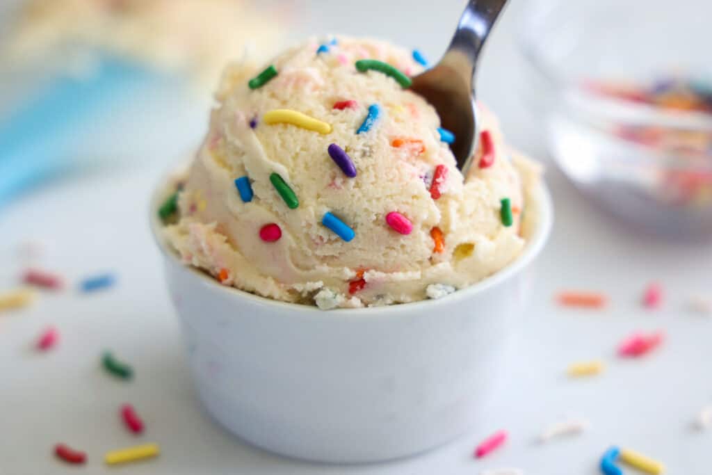 Horizontal image of Edible Sugar Cookie Dough with rainbow sprinkles in a white cup