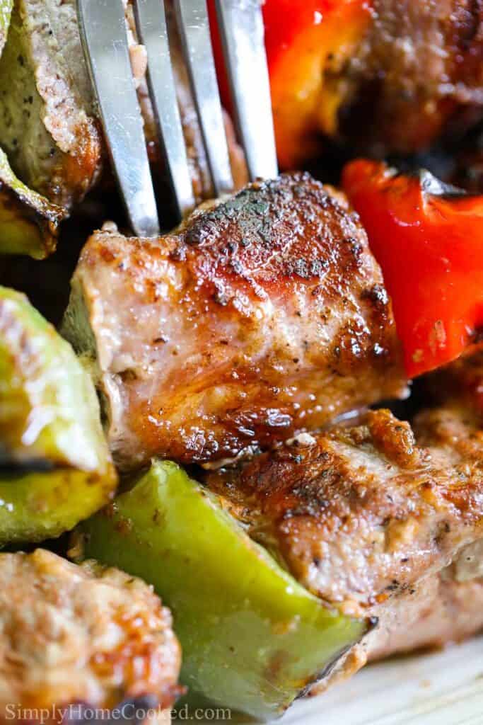 Close up de um garfo em um grelhado de carne de porco a partir de um Shashlik (carne de porco kabob)