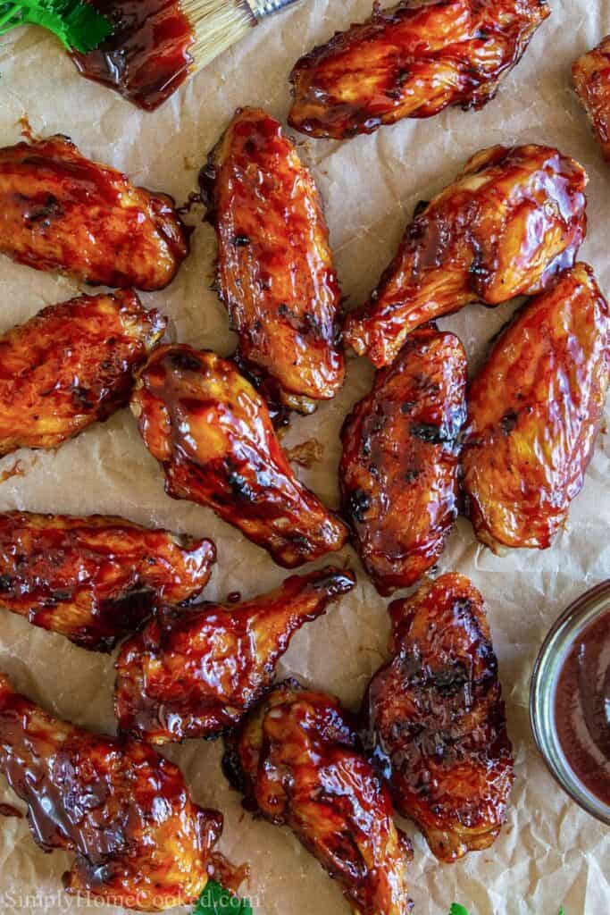 overhead image of grilled bbq chicken wings on a sheet of brown parchment paper