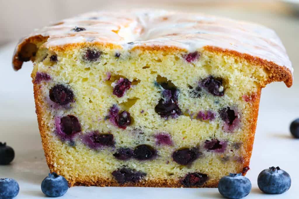 Close up of a loaf of Blueberry Bread with lemon glaze icing.