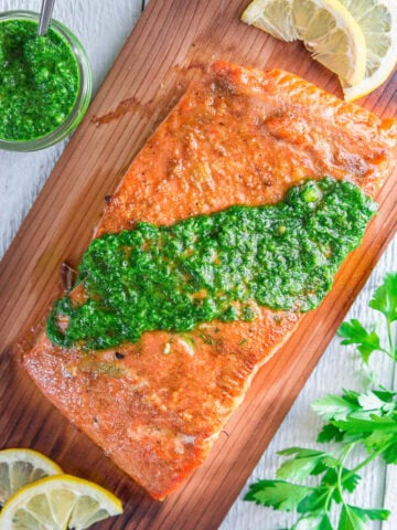 Cedar Plank Salmon on wood and topped with chimichurri sauce.