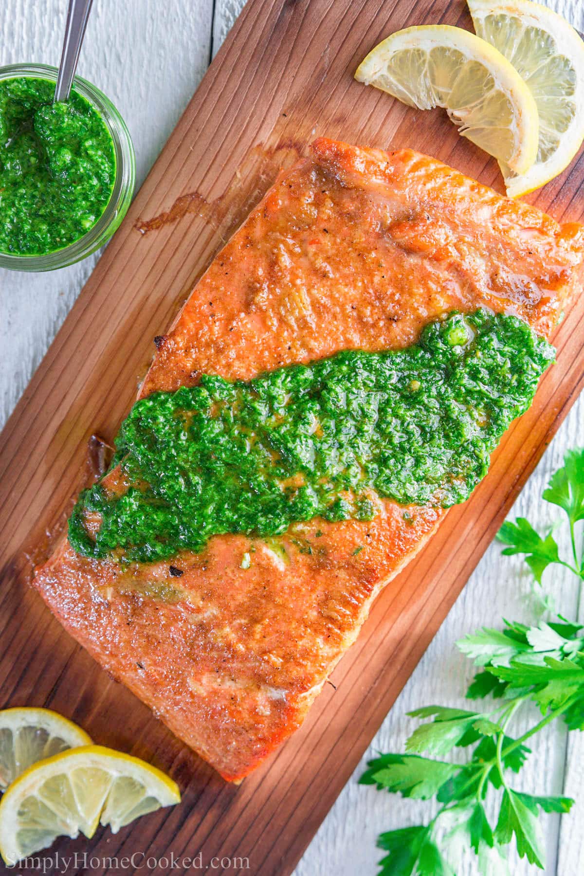 Cedar Plank Salmon on wood and topped with chimichurri sauce.