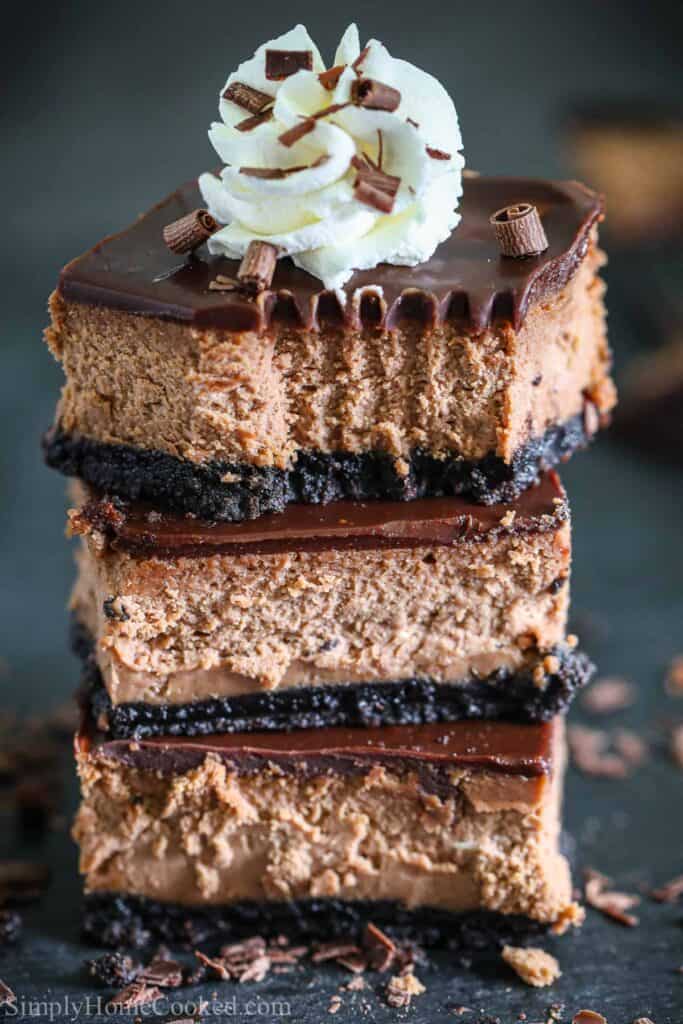Stack of Chocolate Cheese Cake Bars with whipped cream on top