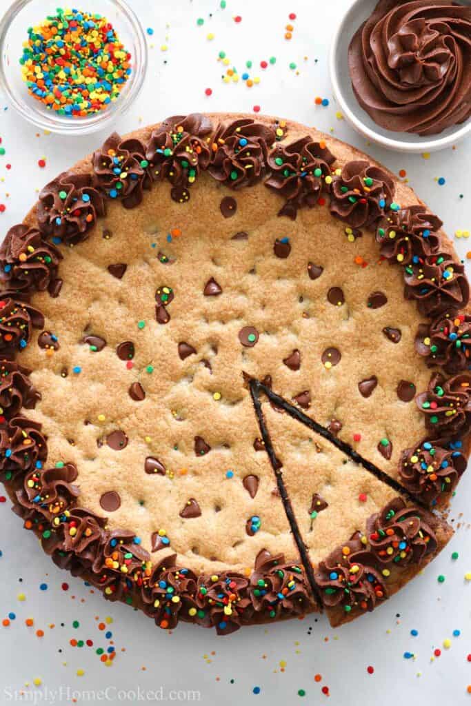 Cookie Cake with buttercream frosting, chocolate buttercream and sprinkles nearby