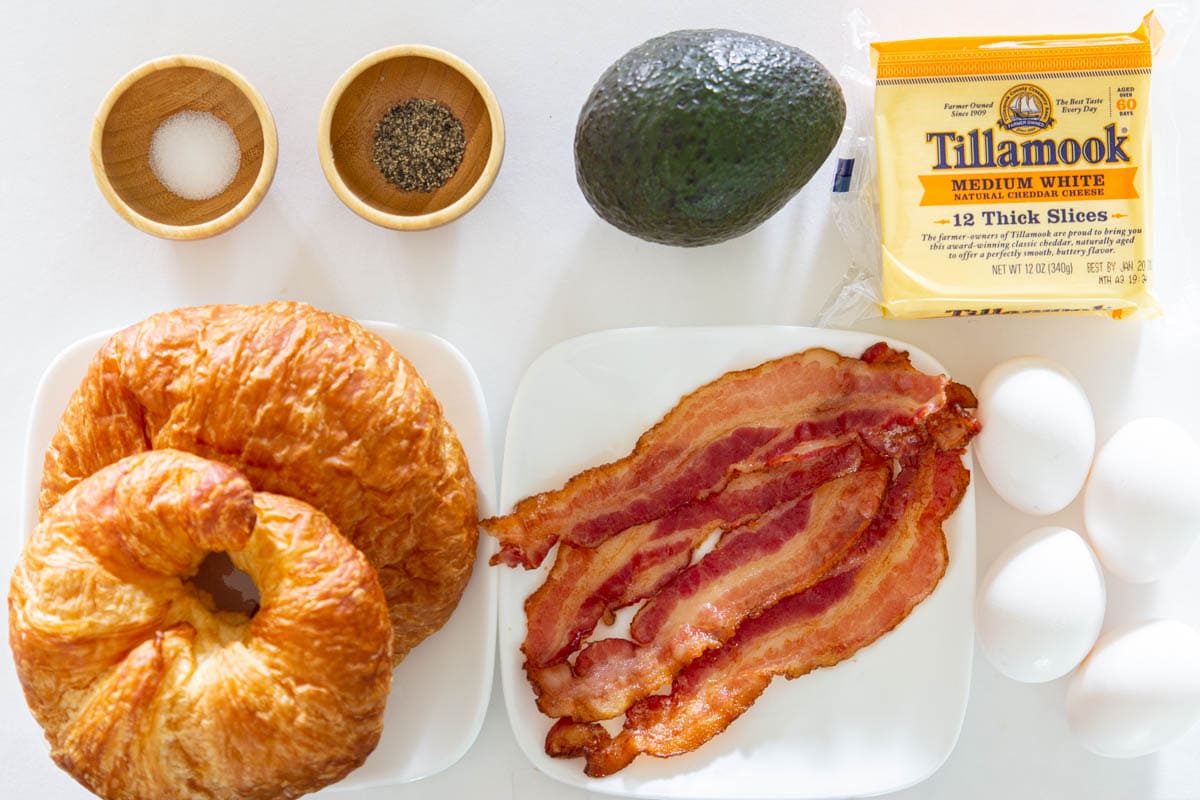 Ingredients for a Croissant Breakfast Sandwich, including Croissants, Eggs, Avocado, Bacon, White cheddar, and Salt & pepper.