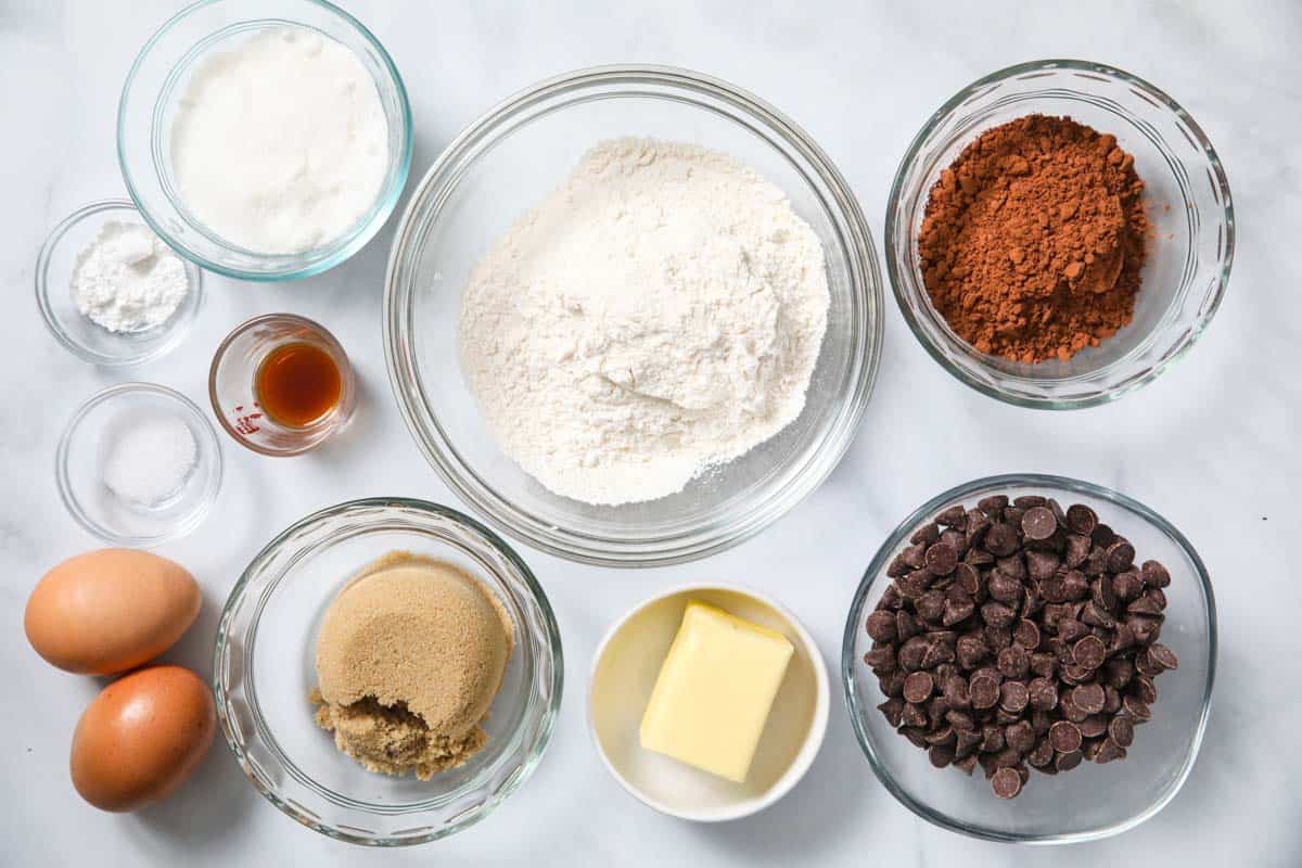 Ingredients for Double Chocolate Cookies, including flour, sugar, brown sugar, cocoa powder, eggs, vanilla, baking powder, salt, butter, and chocolate chips.