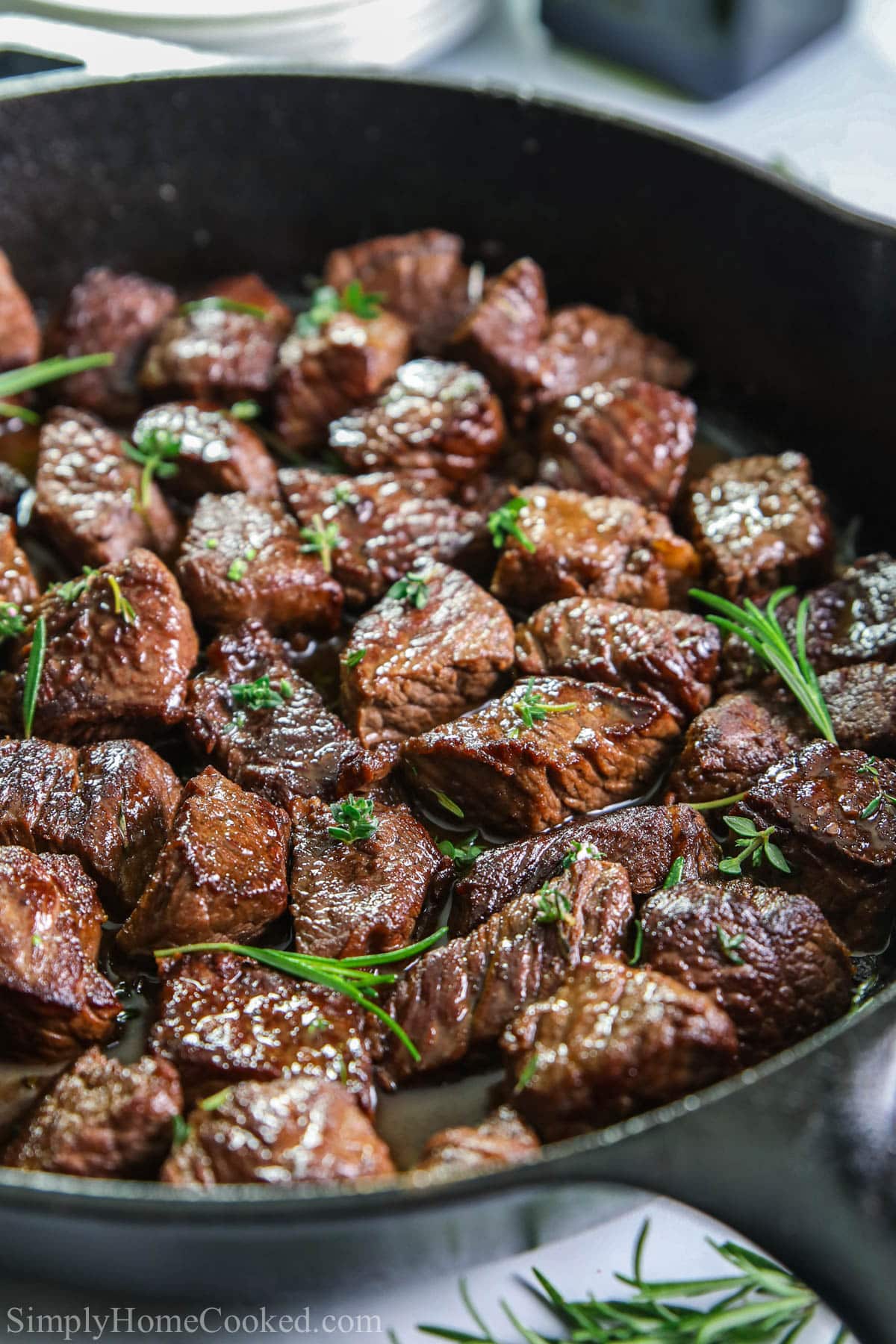 Vertical image of Garlic Butter Steak Bites in a cast iron pan.