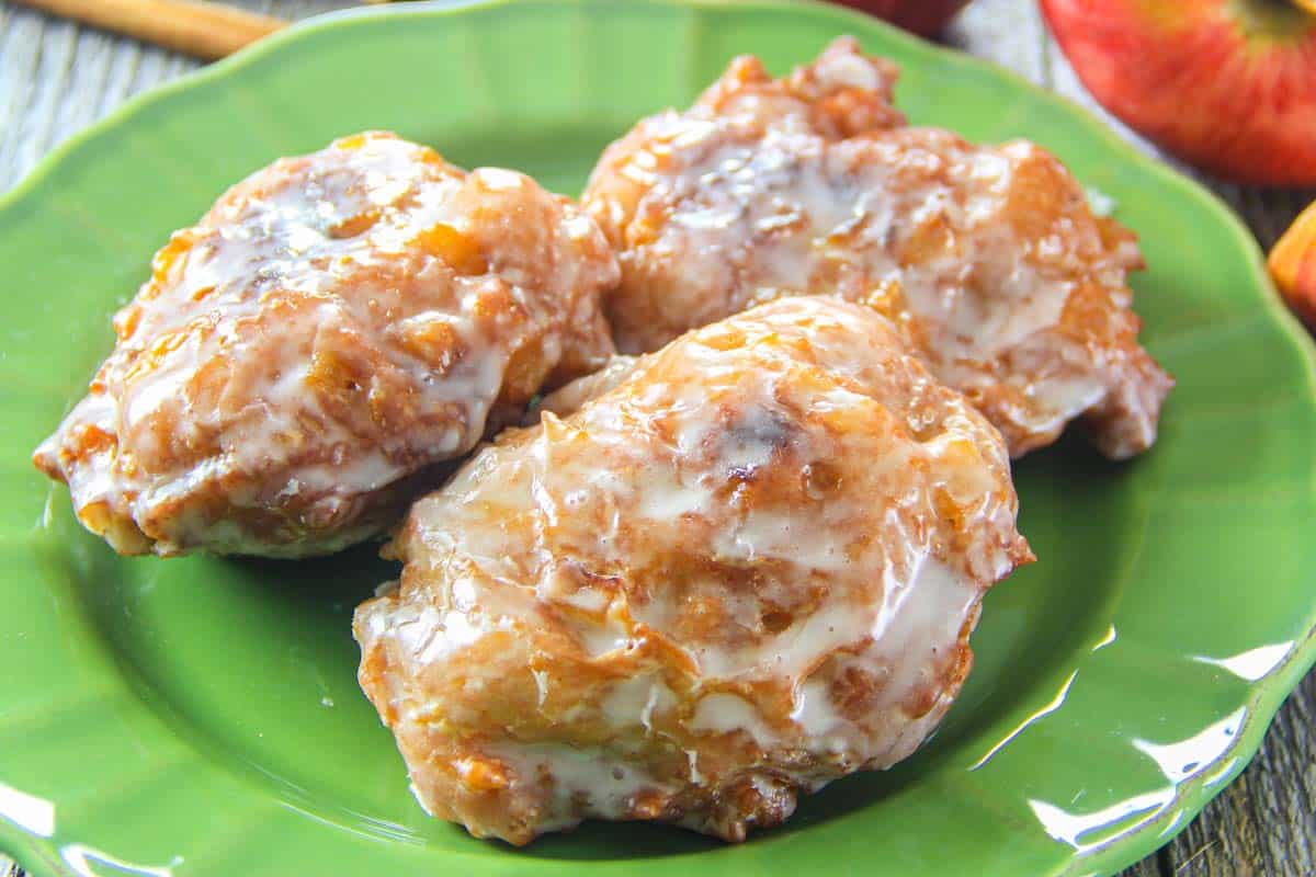 Glazed Apple Fritters on a green plate.