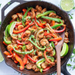 square close up of Shrimp Fajitas in a pan with a wooden spoon