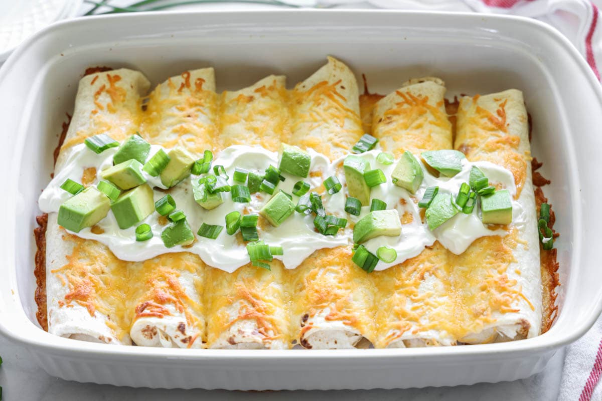 Horizontal image of Easy Chicken Enchiladas with sour cream and chives on top
