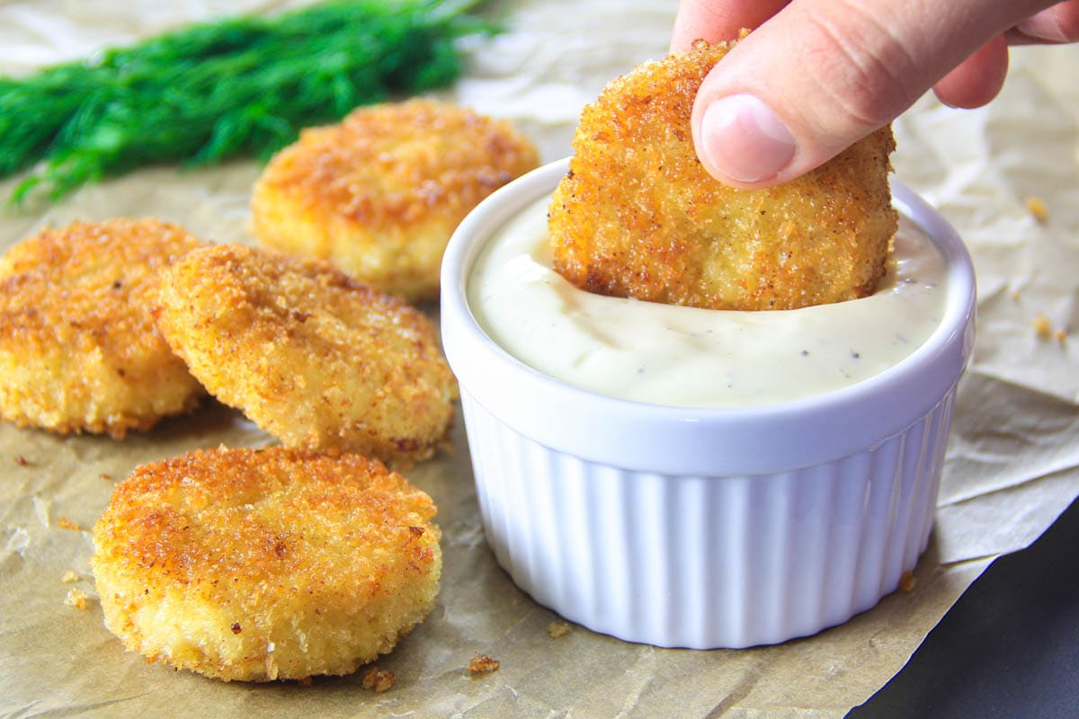 Horizontal image of Healthy Chicken Nuggets with Quinoa being dipped into sauce