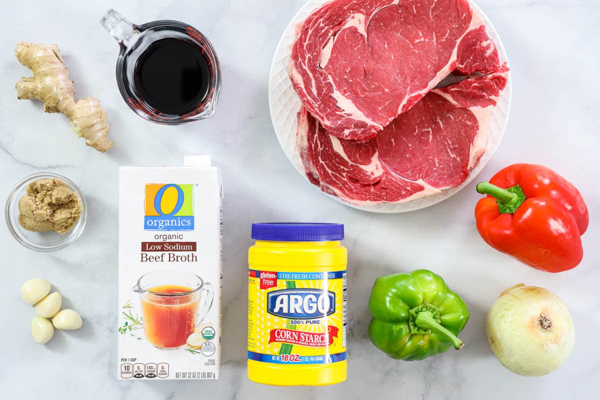 Ingredients for Pepper Steak, including sirloin, red and green peppers, onion, soy sauce, brown sugar, corn starch, ginger, garlic, and beef broth. 