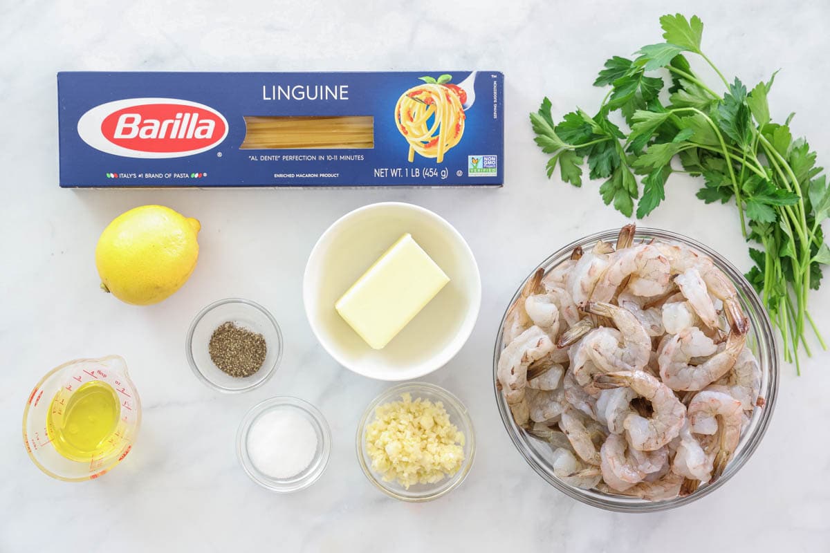 an overhead image of ingredients for shrimp linguine on a white background