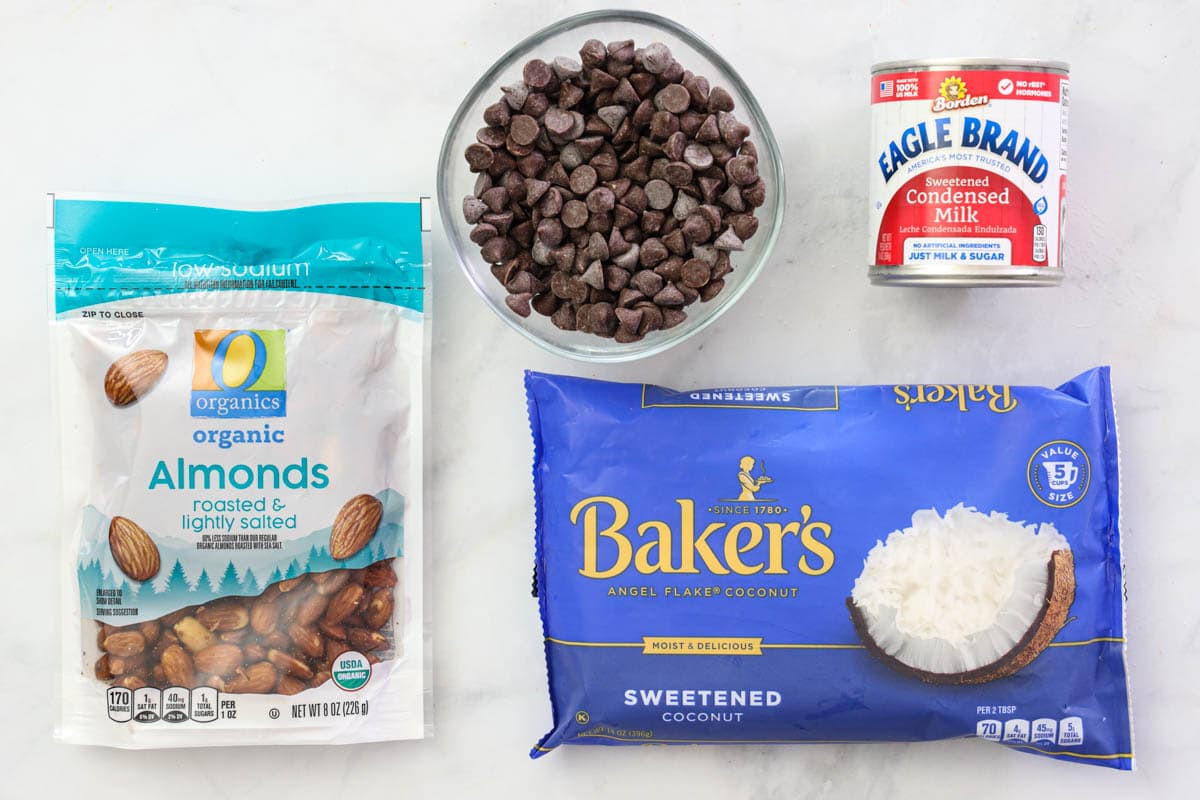 Ingredients for Almond Joy Cookies, including sweetened coconut, sweetened condensed milk, almonds, and chocolate chips.