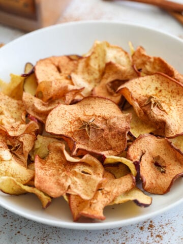 Crispy Air Fryer Apple Chips with cinnamon sticks on the side