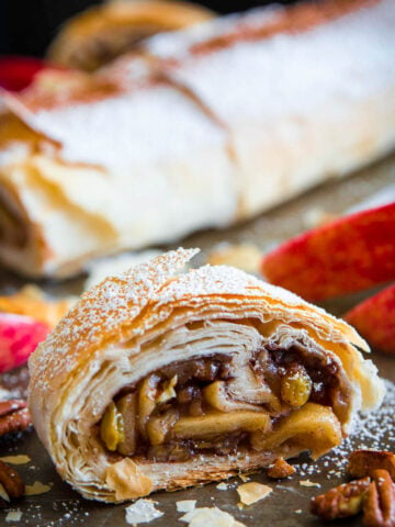Vertical image of Apple Strudel cut in half, and another in the background.
