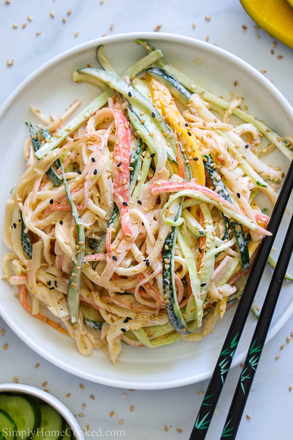 Vertical image of Kani Salad with chopsticks on the side of the plate.