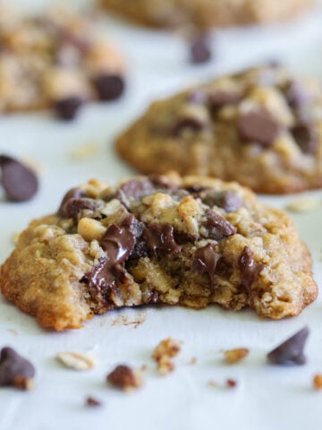 Vertical image of Oatmeal Chocolate Chip Cookies, one missing a bite