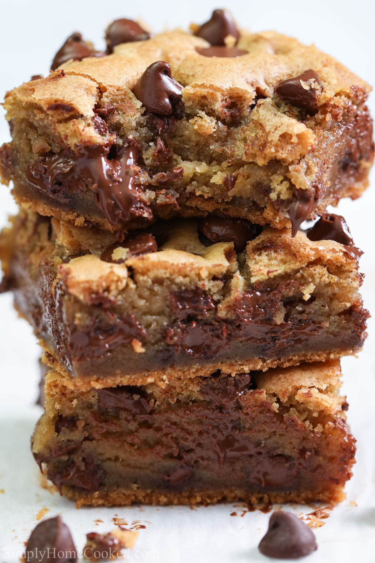 Vertical close up image of Chocolate Chip Cookie Bars stacked and one missing a bite