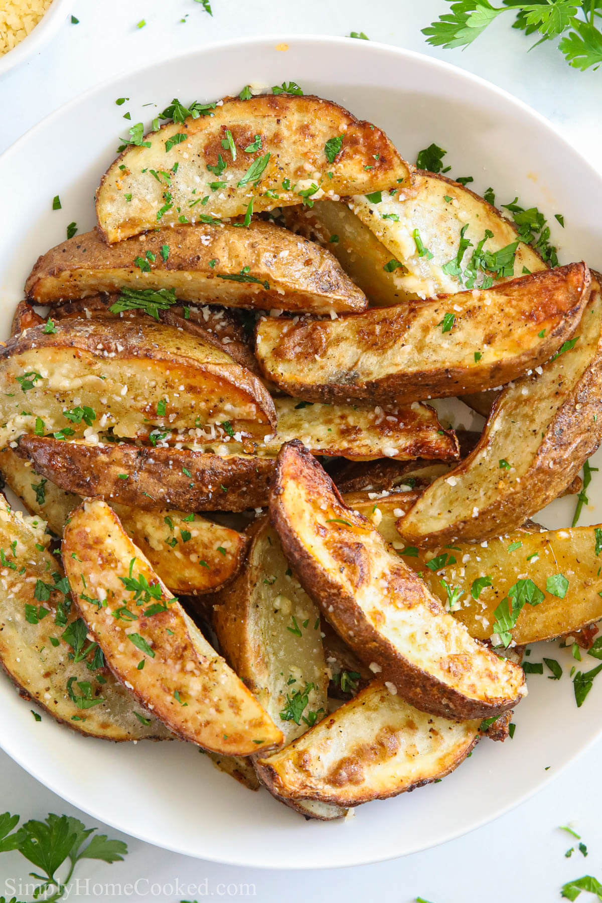 Vertical image of Air Fryer Potato Wedges in a white dish