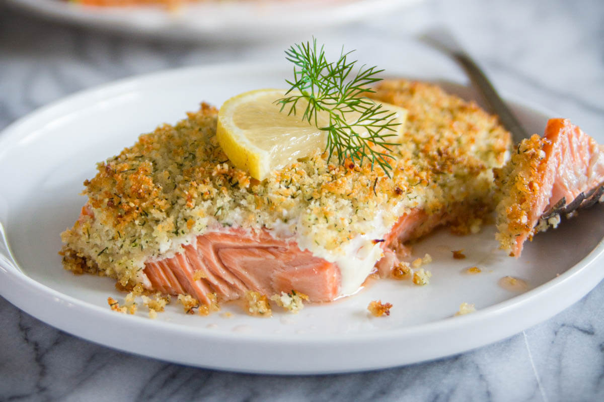 Horizontal image of a plate of Panko Crusted Salmon topped with dill and lemon
