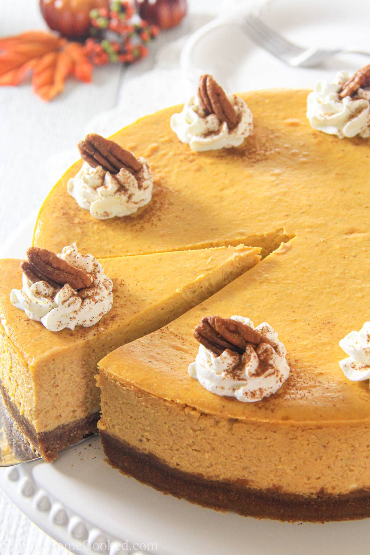 Pumpkin Cheesecake topped with pecans and whipped cream