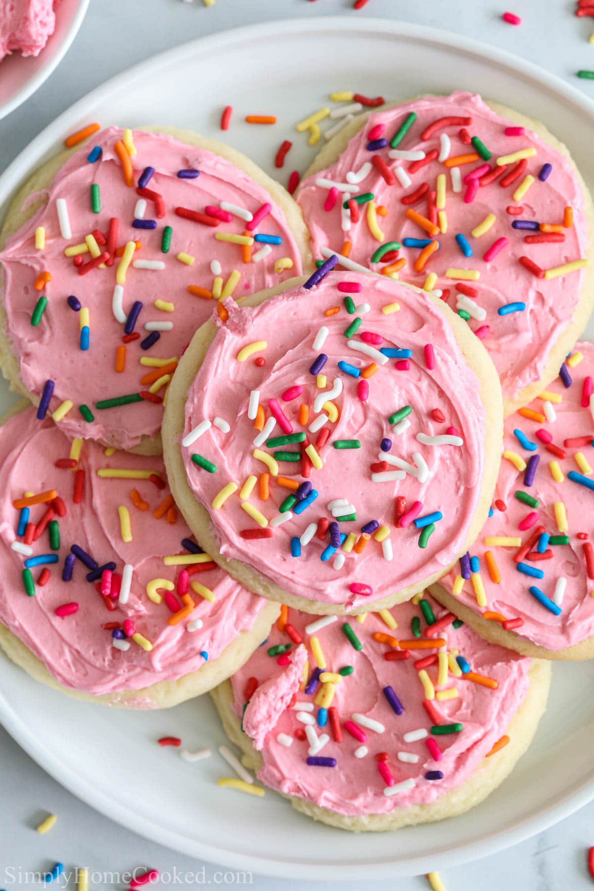 overhead image of pink lofthouse cookies with rainbow sprinkles on top.