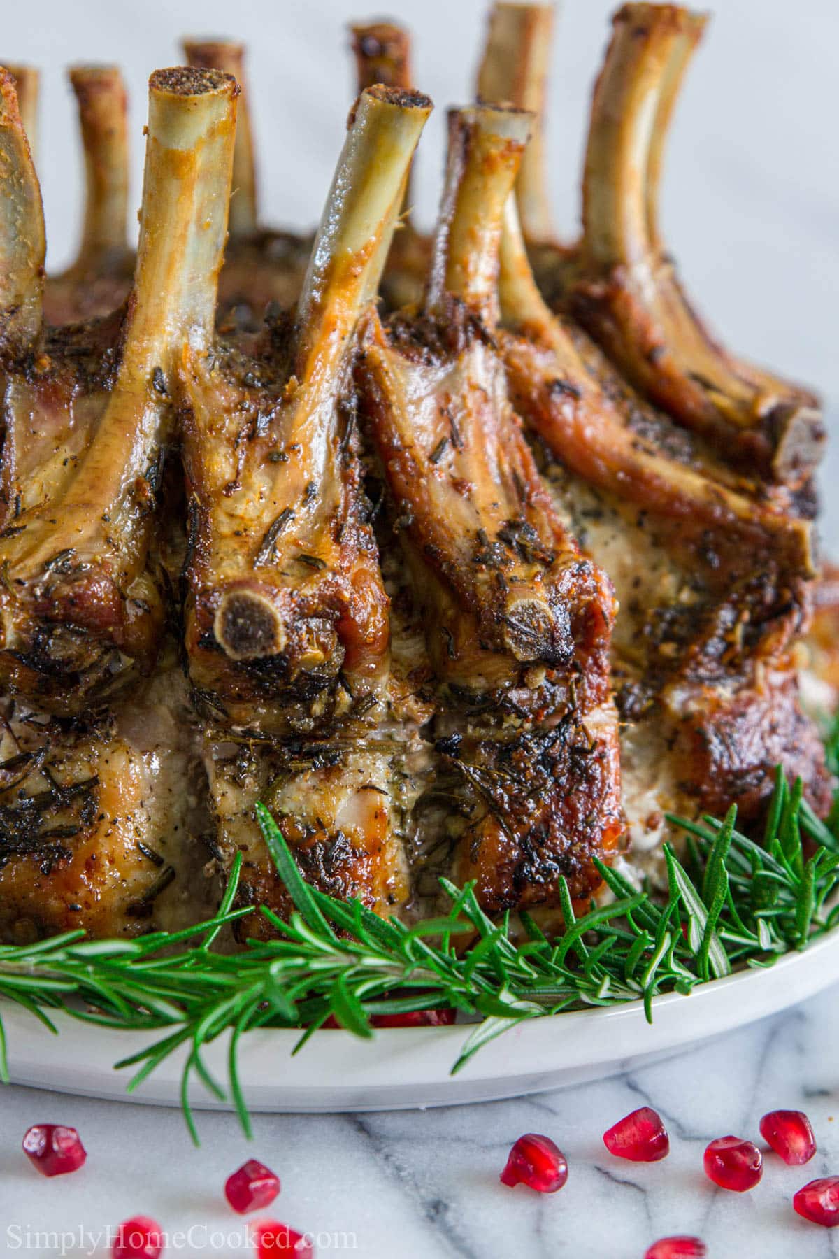 Pork Crown Roast surrounded by rosemary and pomegranate seeds.