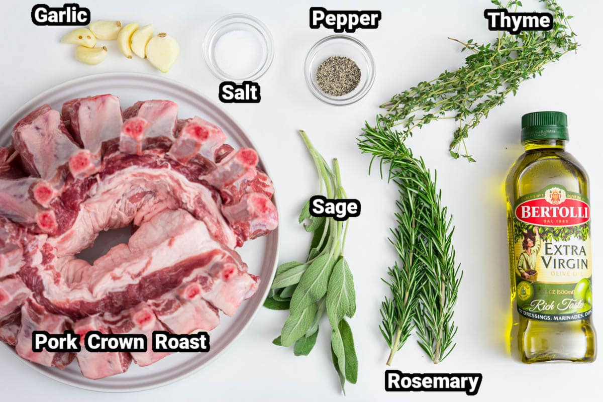 Ingredients for Pork Crown Roast, including crown of pork, olive oil, salt, pepper, thyme, rosemary, sage, and garlic cloves.