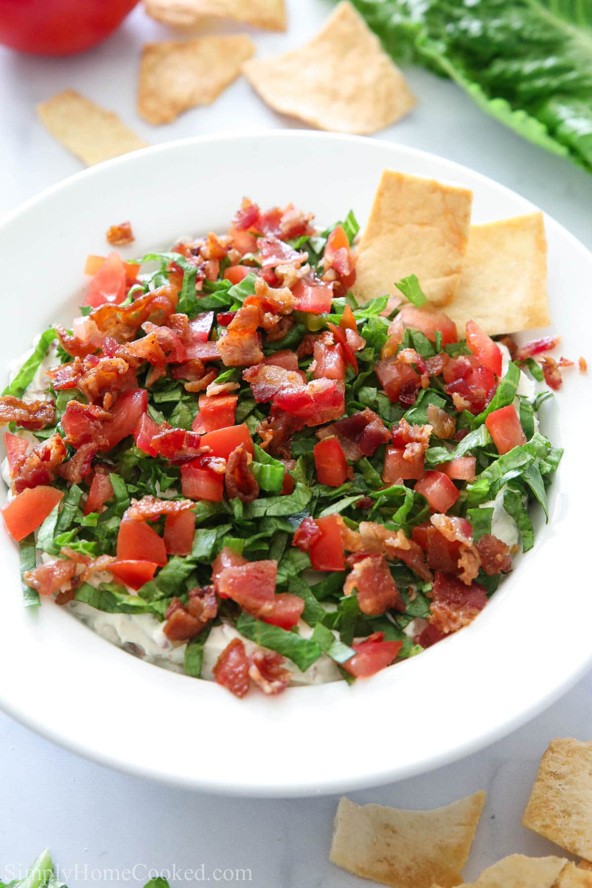 Vertical overhead image of a bowl of Easy BLT Dip with pita crackers to the side