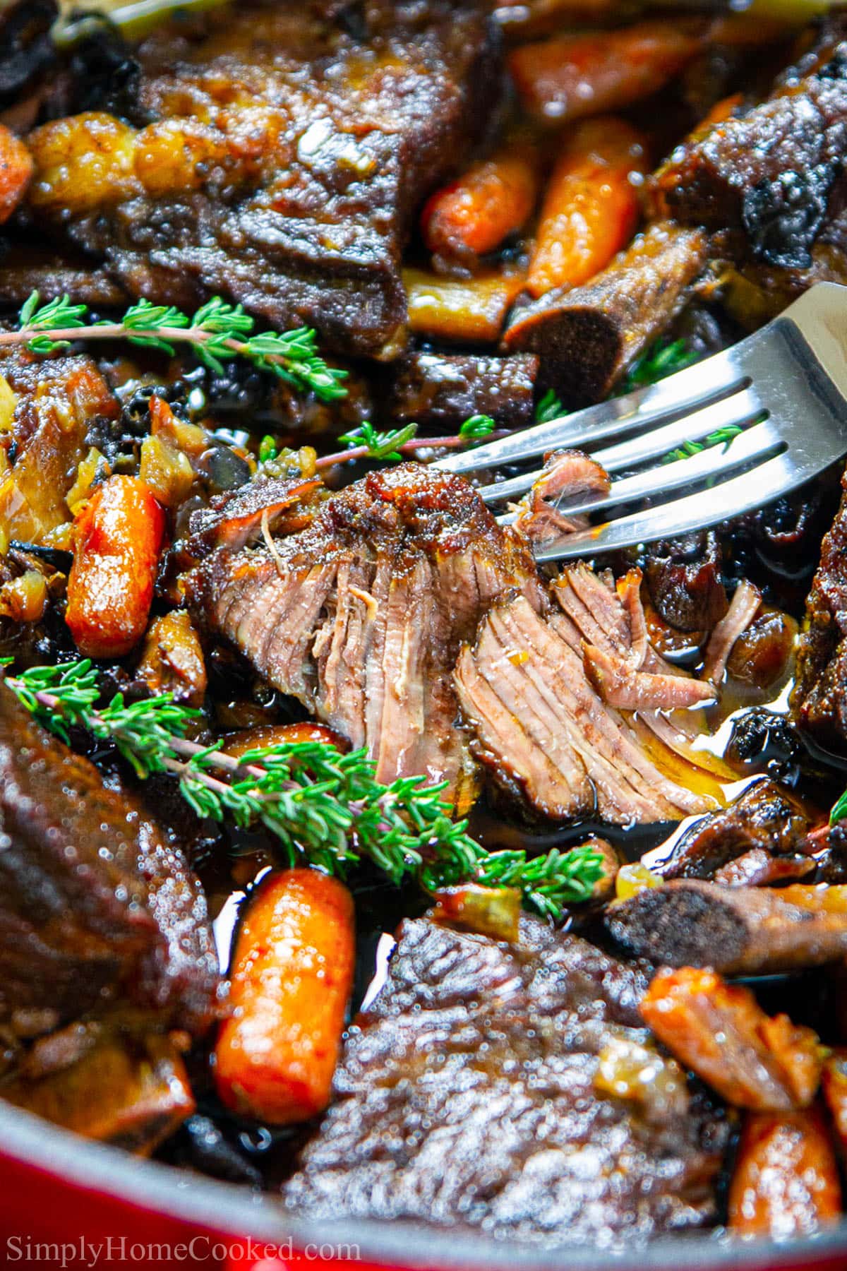 Vertical close up image of Braised Beef Short Ribs on a fork