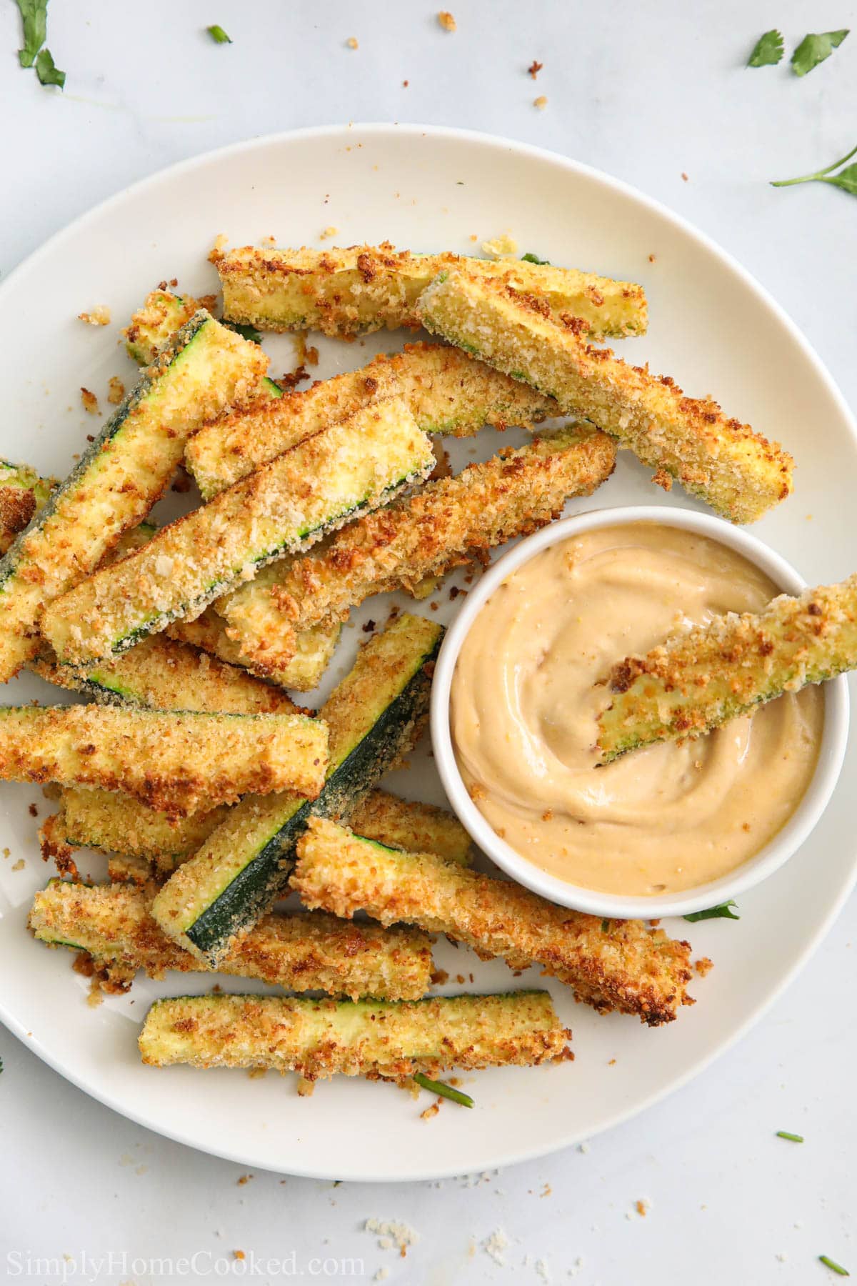 Air Fryer Zucchini Fries on a white plate with a dipping sauce in a ramekin