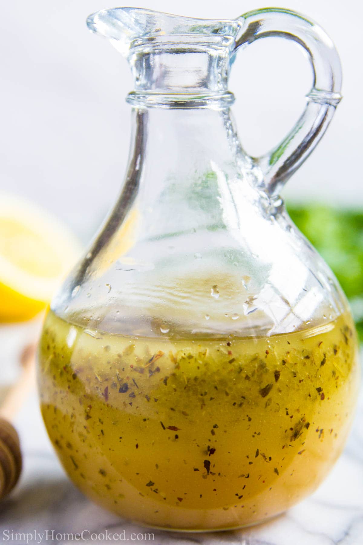 Vertical image of Greek Salad Dressing in a glass dressing bottle