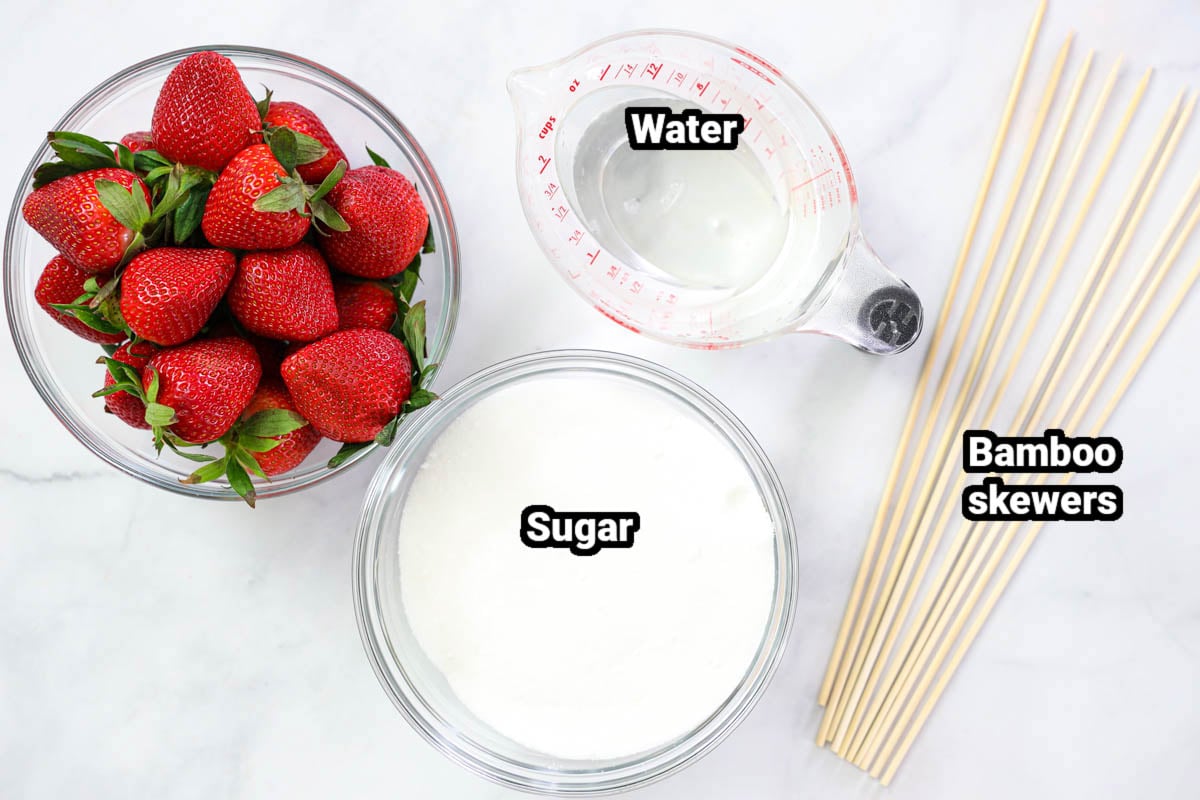 Ingredients for Strawberry Tanghulu, including water, sugar, strawberries, and bamboo skewers.