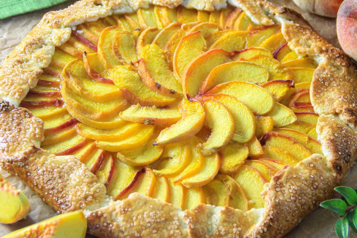 Peach Galette with peaches nearby
