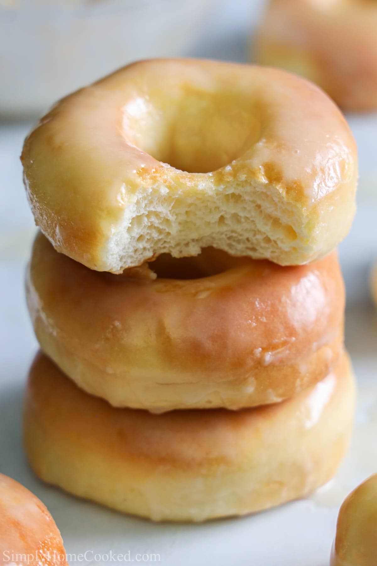 Stack of Glazed Air Fryer Donuts, the top one missing a bite