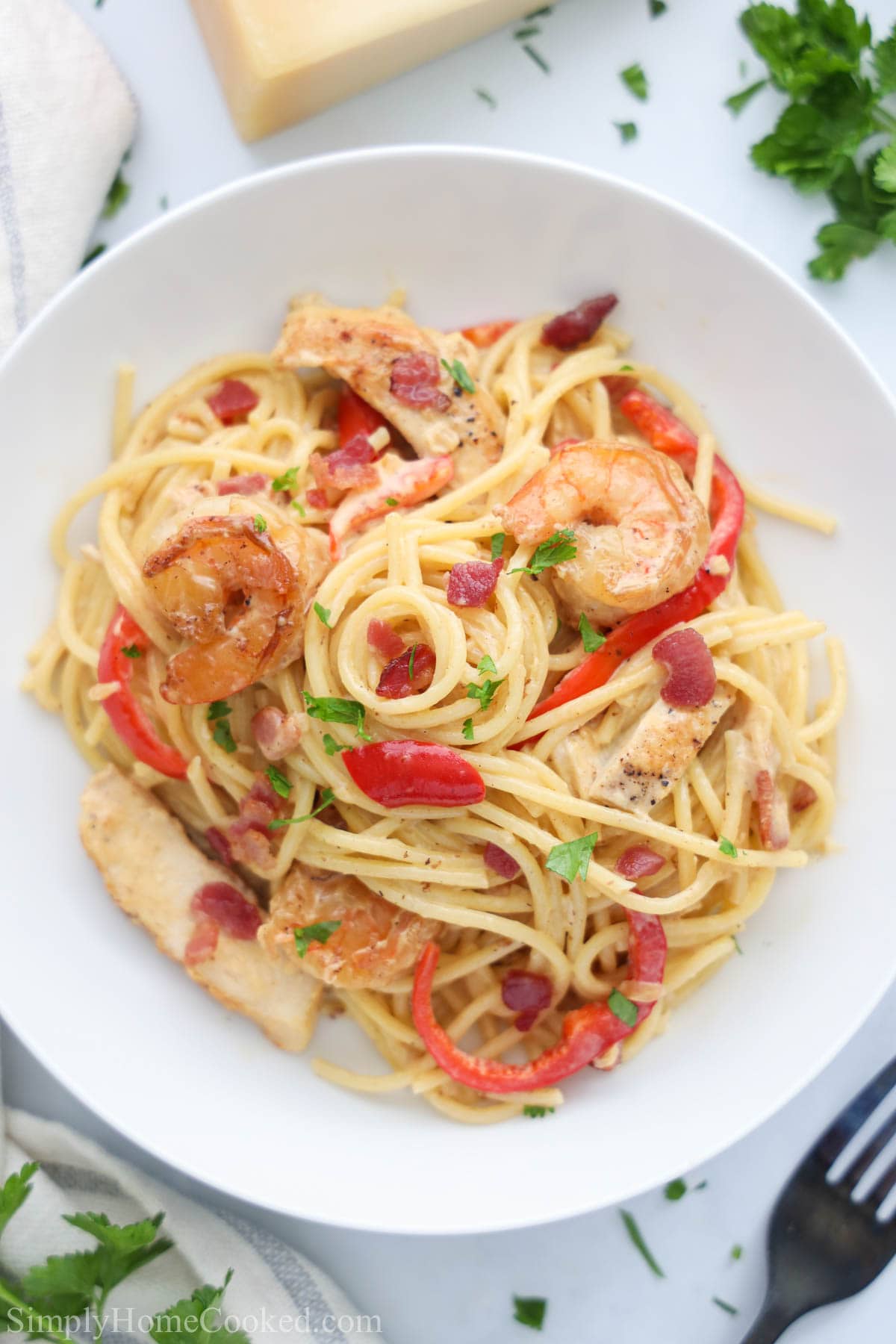 Chicken and Shrimp Carbonara on a white plate with a fork nearby