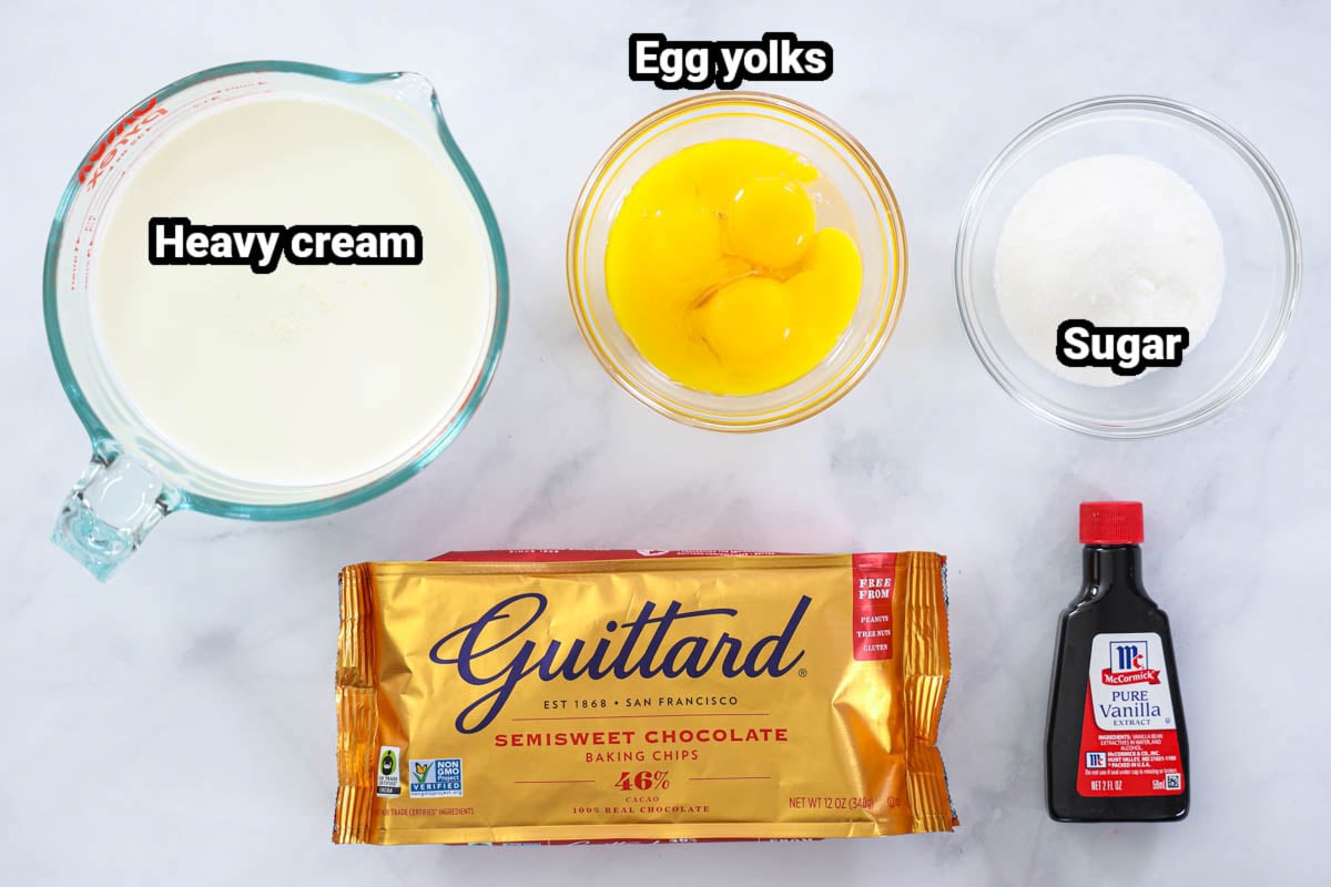Ingredients for Chocolate Creme Brulee, including heavy cream, egg yolks, sugar, chocolate chips, and vanilla. 