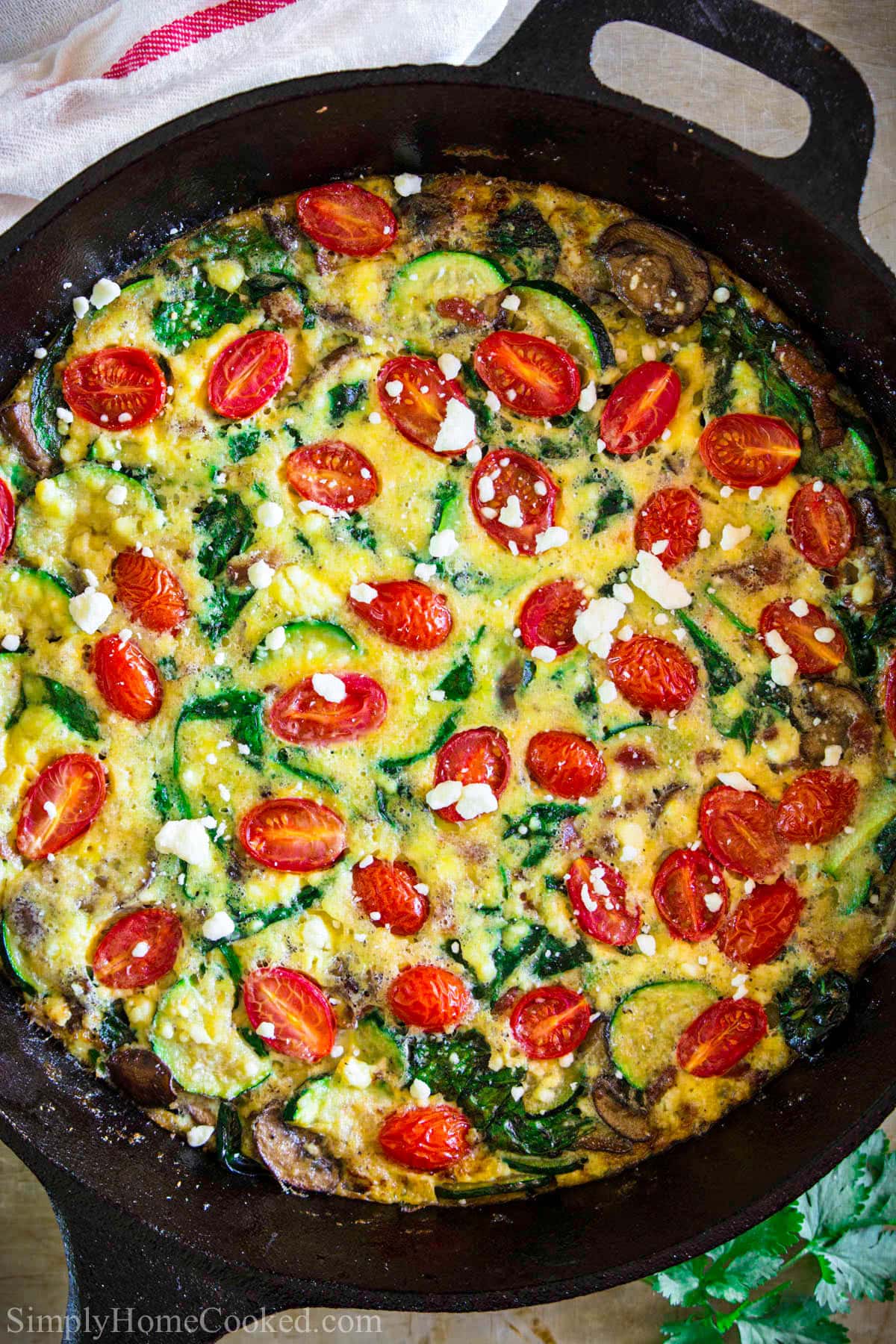 Zucchini Frittata in a cast iron skillet with feta cheese on top