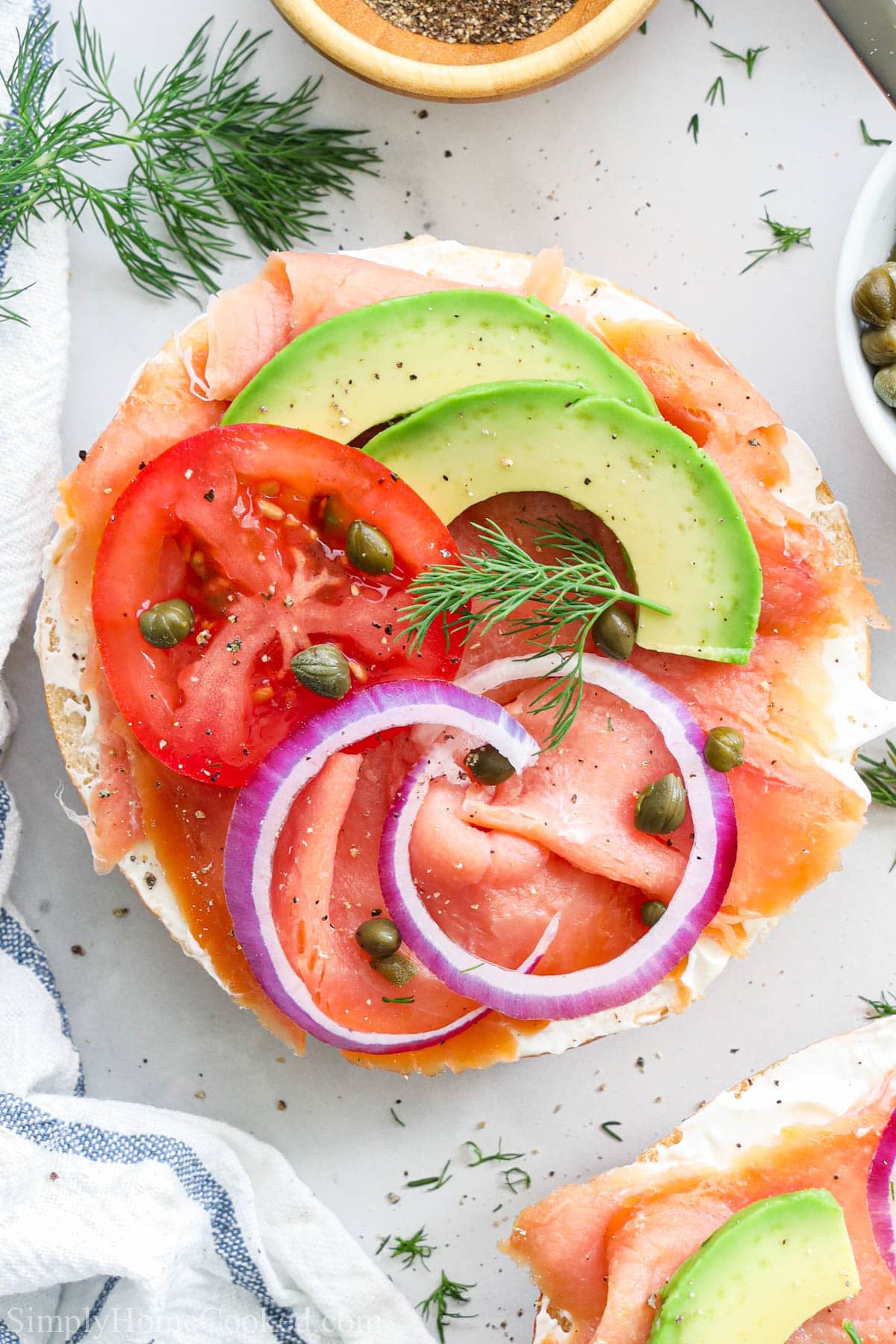 Smoked Salmon Bagel topped with onion, capers, tomato, dill, and avocado.