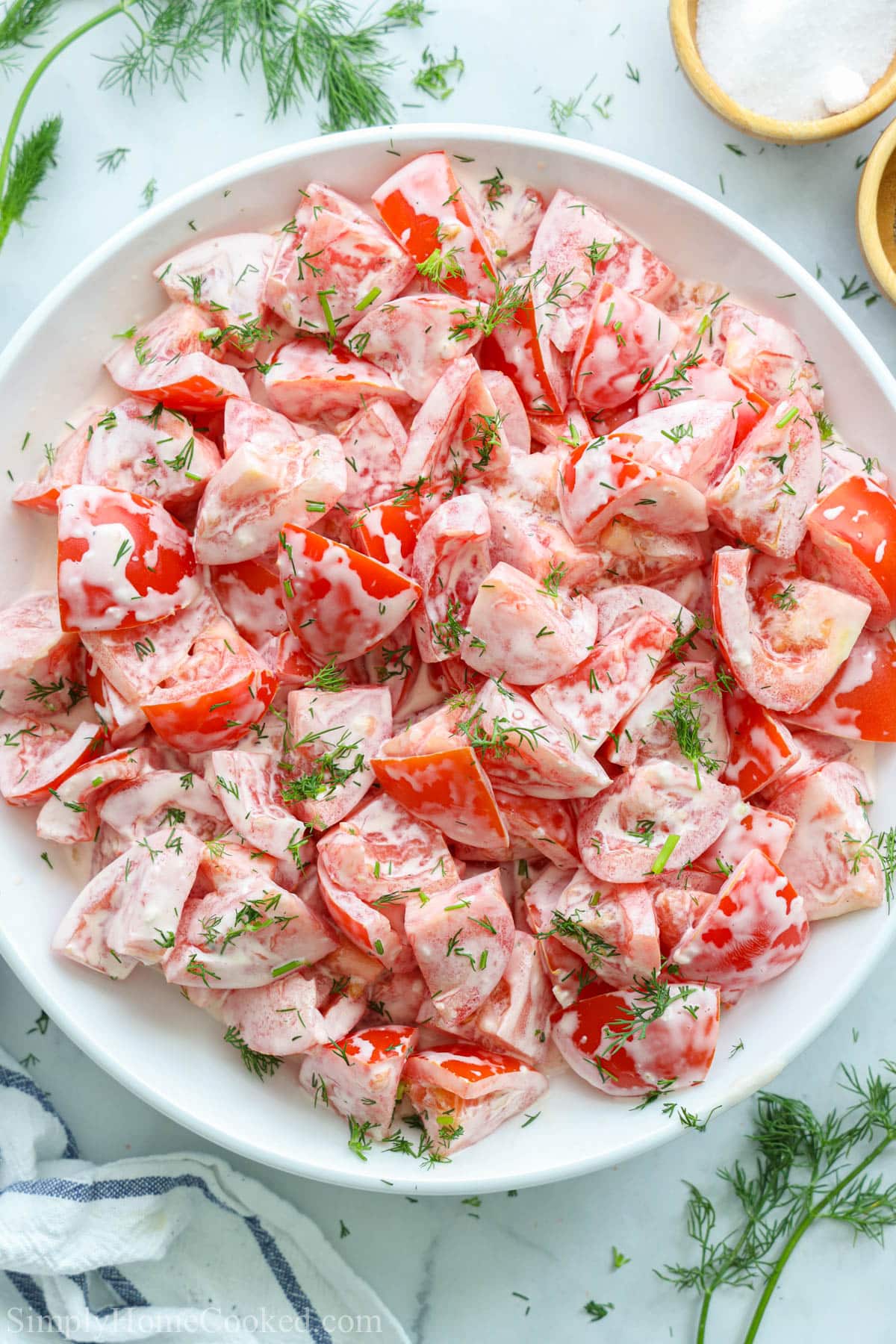 Plate of Tomato Garlic Salad topped with fresh dill.