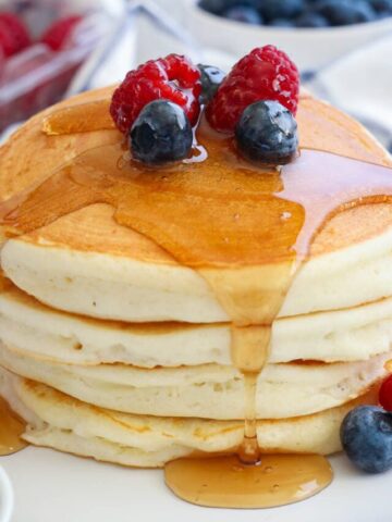 Stack of Buttermilk Pancakes topped with berries and syrup