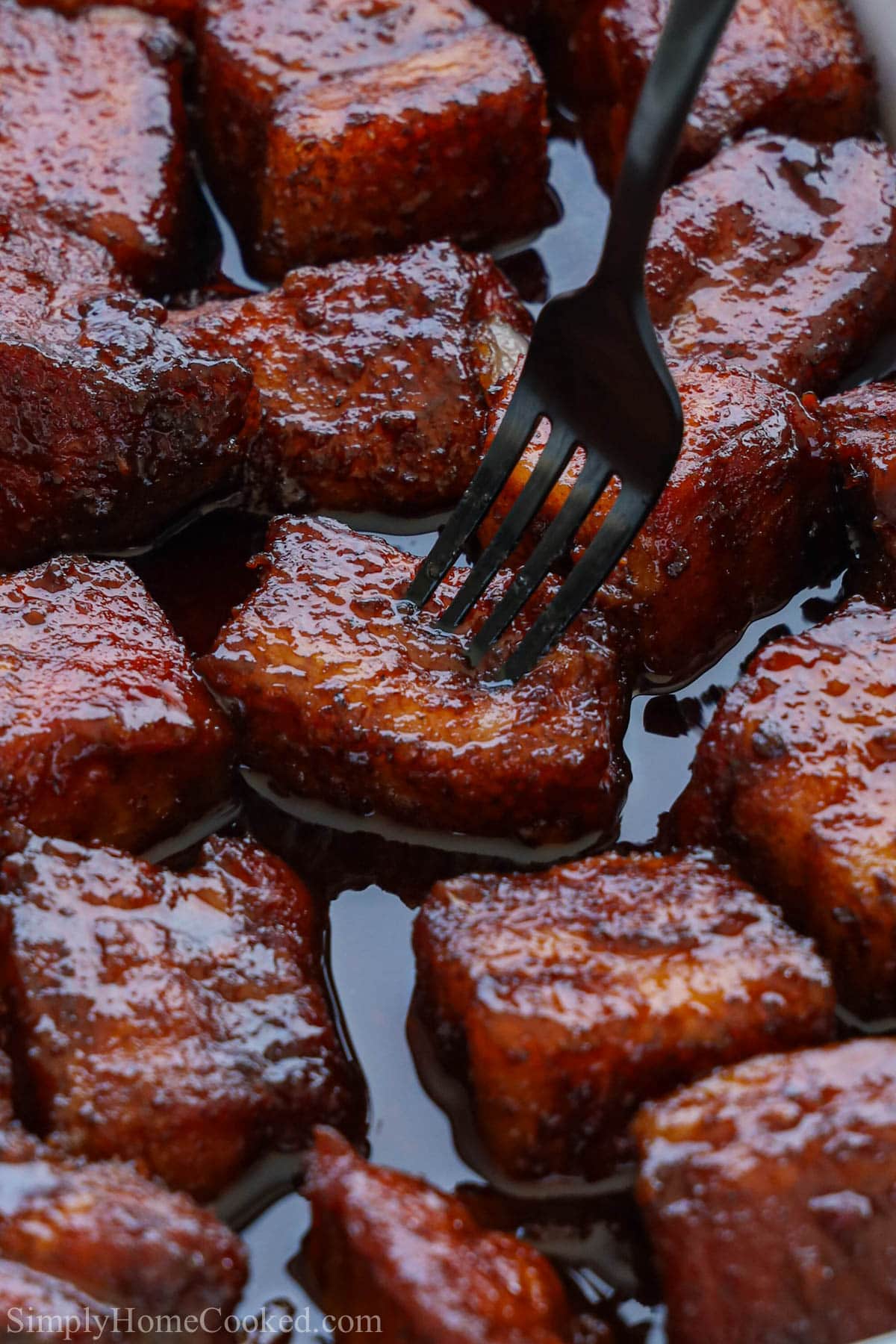 Close up of Pork Belly Burnt Ends with a fork