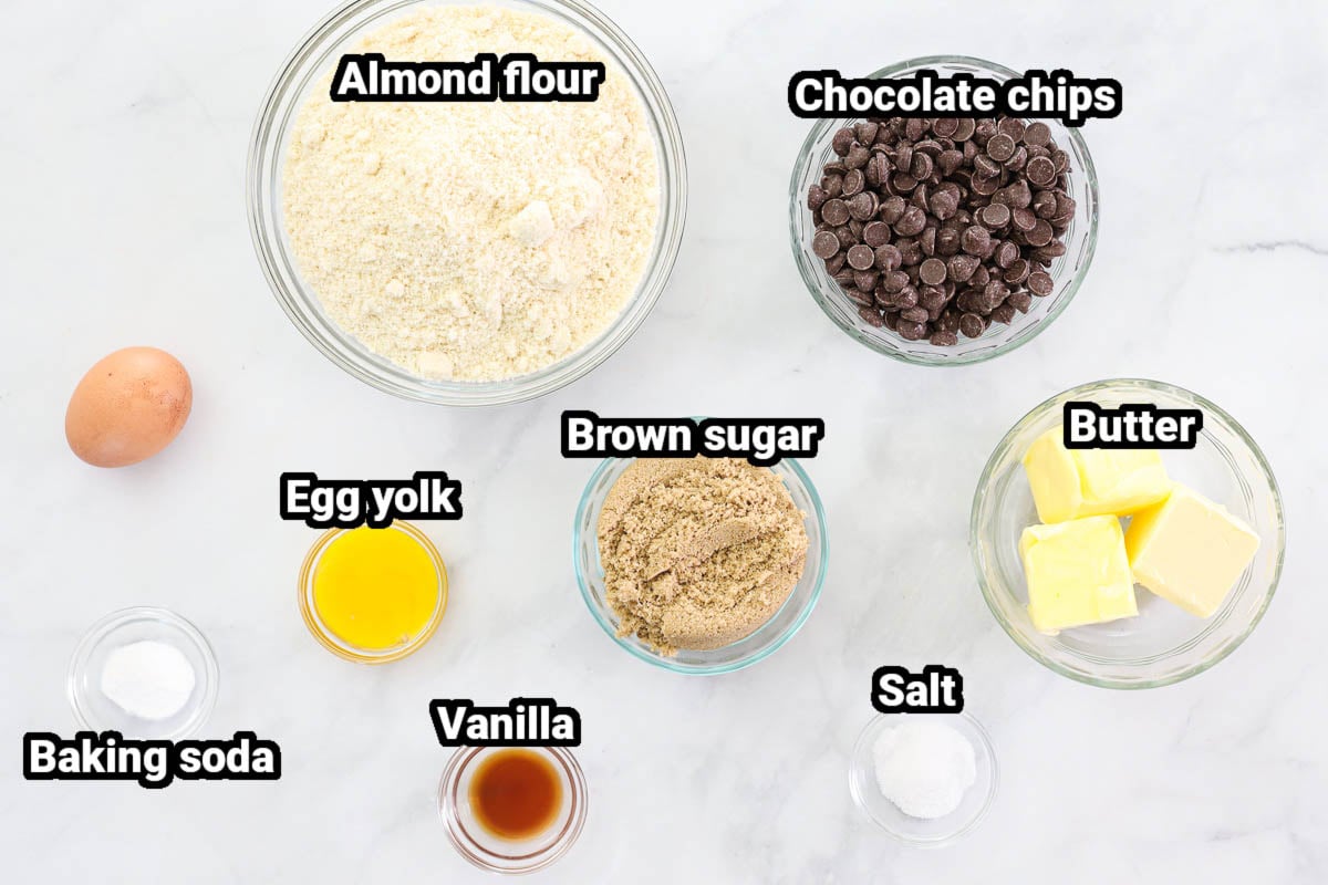 Ingredients for Almond Flour Chocolate Chip Cookies: almond flour, chocolate chips, egg yolk, egg, brown sugar, butter, baking soda, vanilla, and salt.