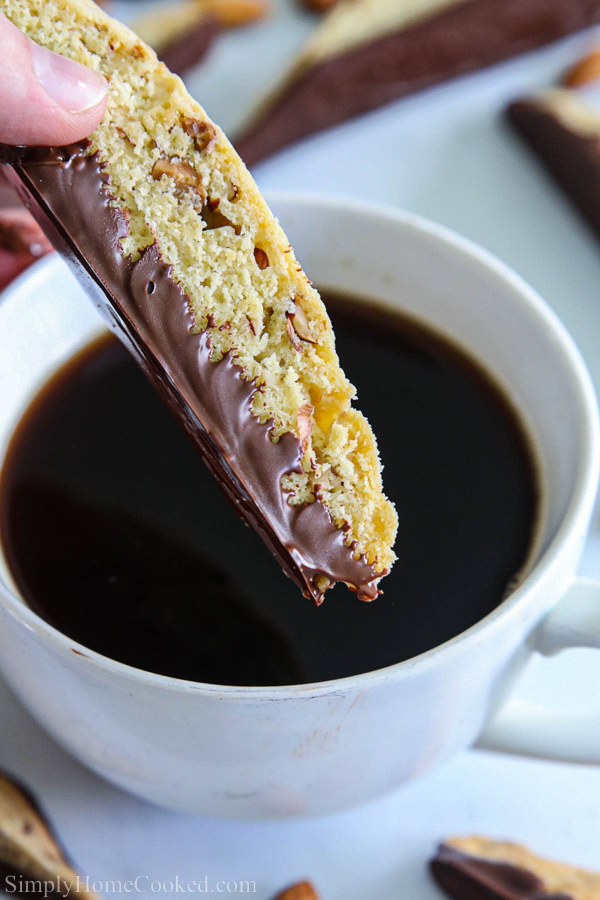 Chocolate Dipped Almond Biscotti being dunked into a cup of coffee.