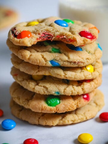 Stack of Chewy M&M Cookies, the top one missing a bite.