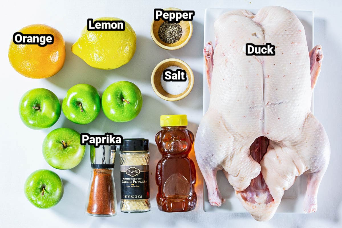Ingredients for Roast Duck recipe: duck, orange, lemon, salt, pepper, apples, paprika, garlic powder, and honey.