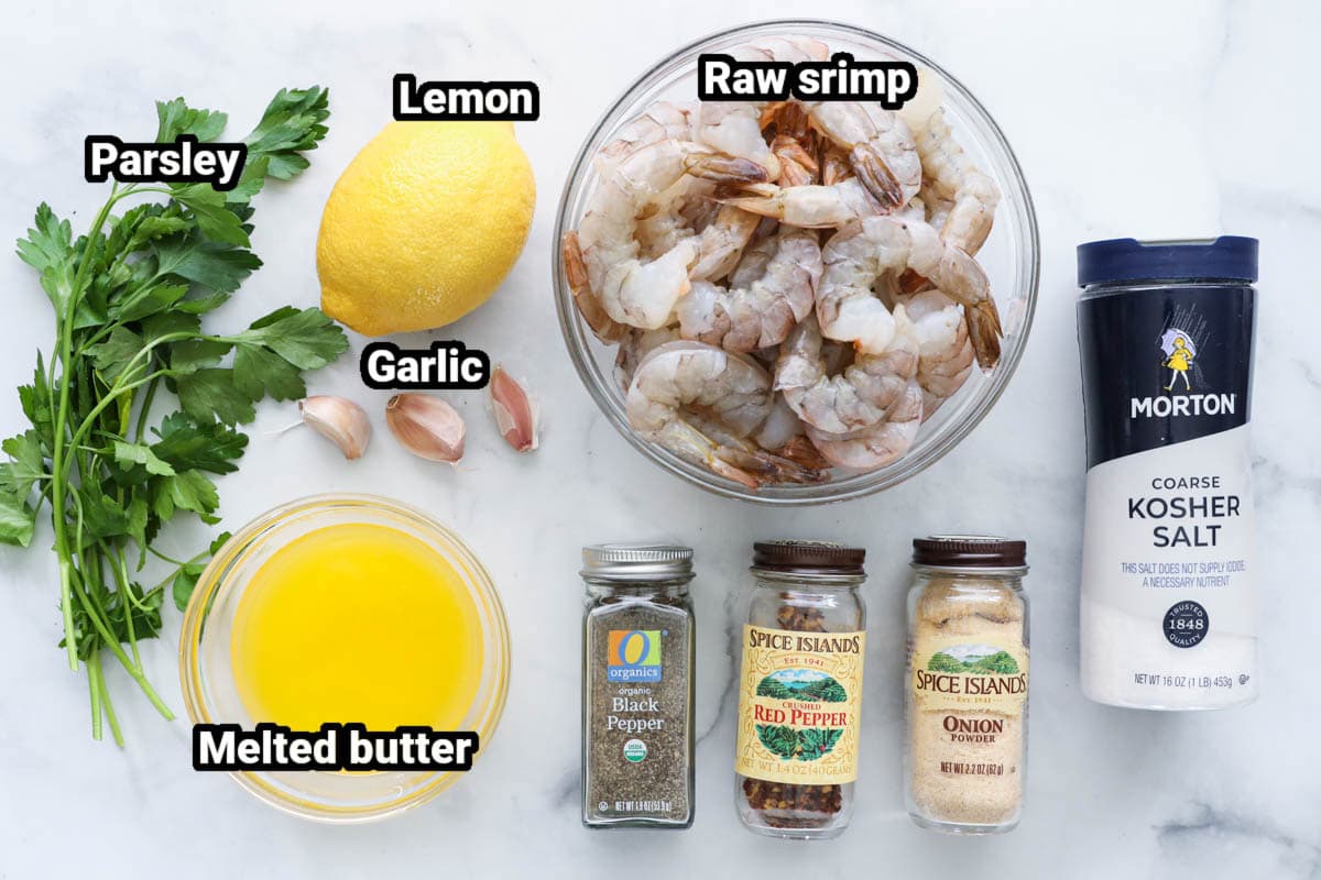 Ingredients for Baked Shrimp: shrimp, lemon, melted butter, parsley, garlic cloves, kosher salt, black pepper, red pepper flakes, and onion powder.
