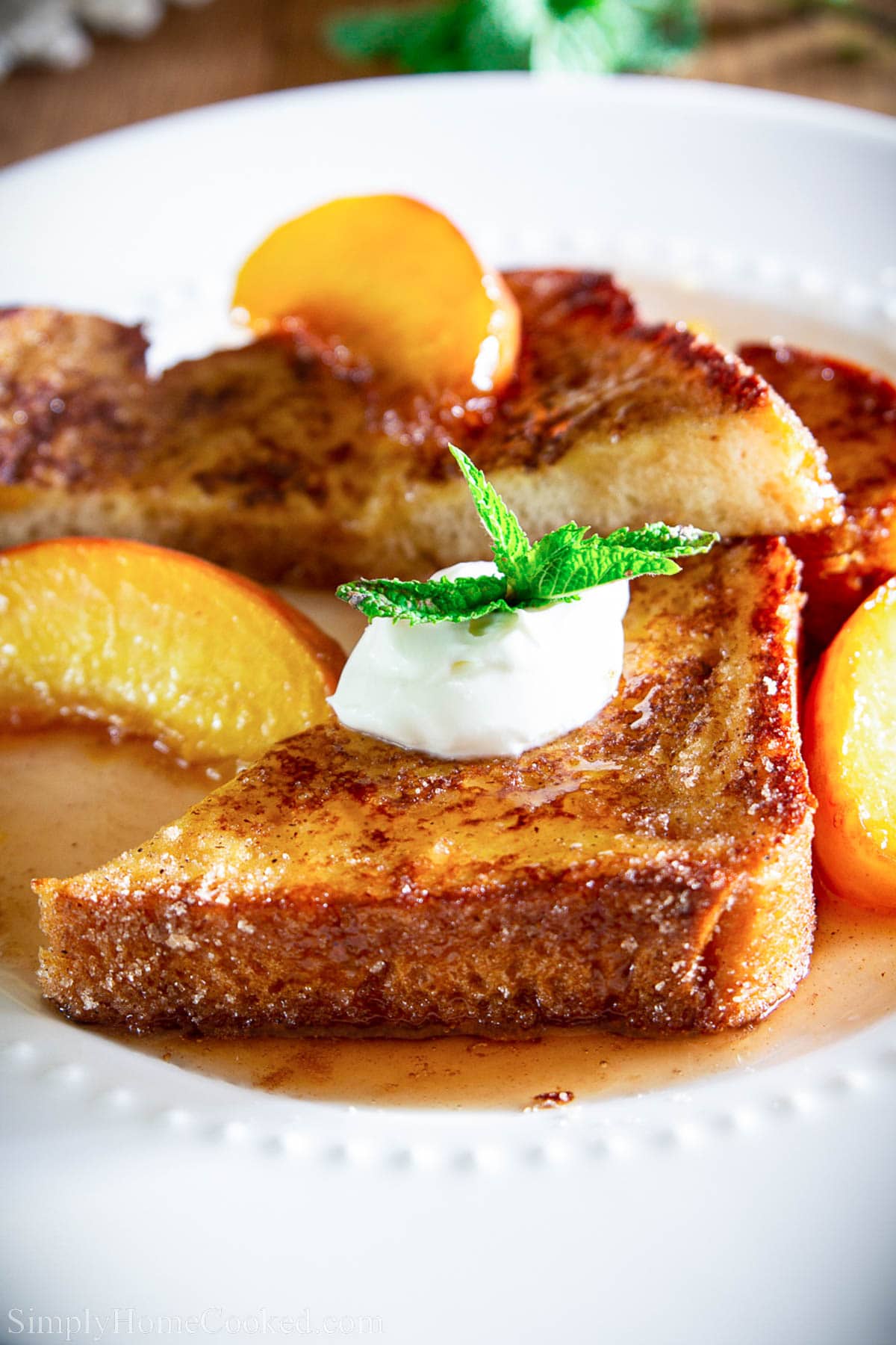 Peach French Toast topped with peach rum syrup, creme fraiche, and a spring of mint.