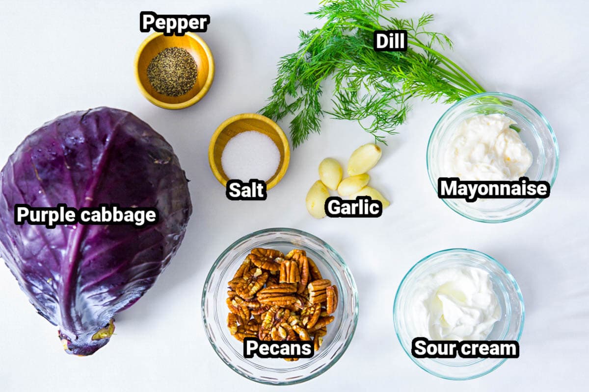 Ingredients for Purple Cabbage Salad: purple cabbage, dill, mayonnaise, sour cream, garlic cloves, salt, black pepper, and pecans.